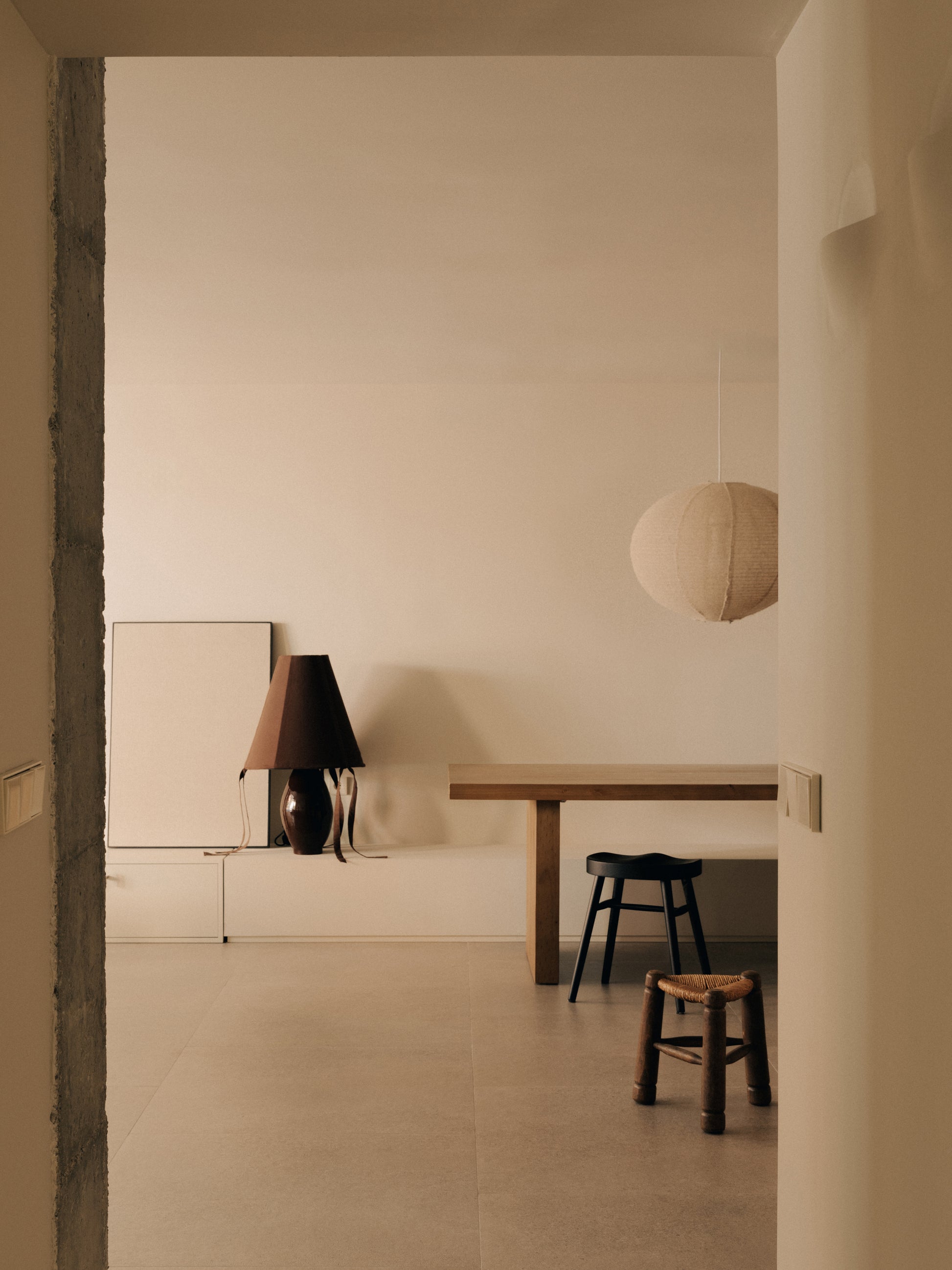 Brown ceramic table lamp styled in minimalist dining space with wood furniture and soft neutral palette