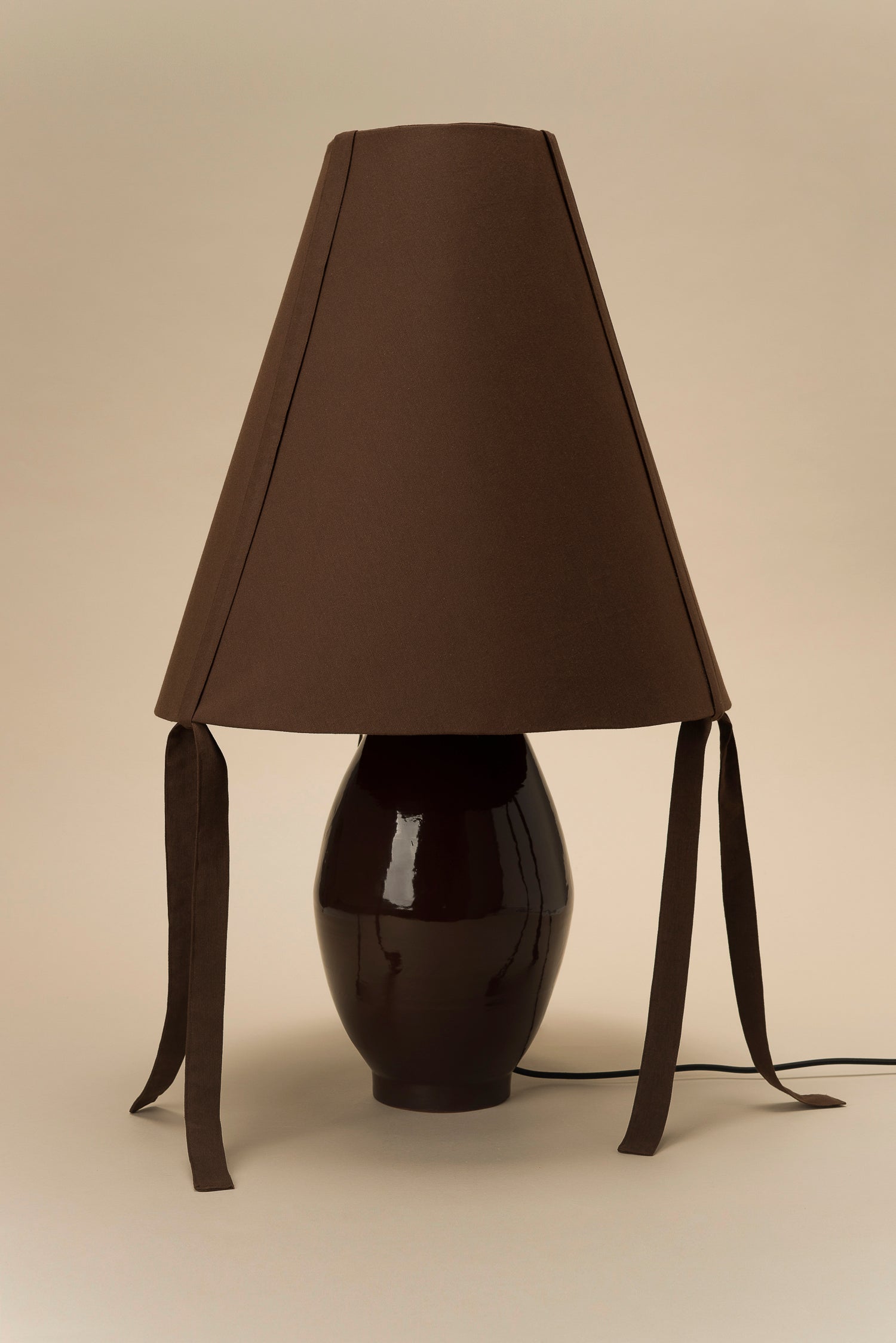 Glossy brown ceramic lamp with cotton pyramid shade and corner ties by Los Objetos Decorativos