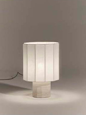 Table lamp with a fluted dodecagon white linen shade and matching white travertine base on a gray background